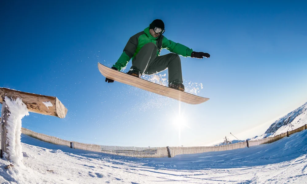 Snowboarder jumping from a rail