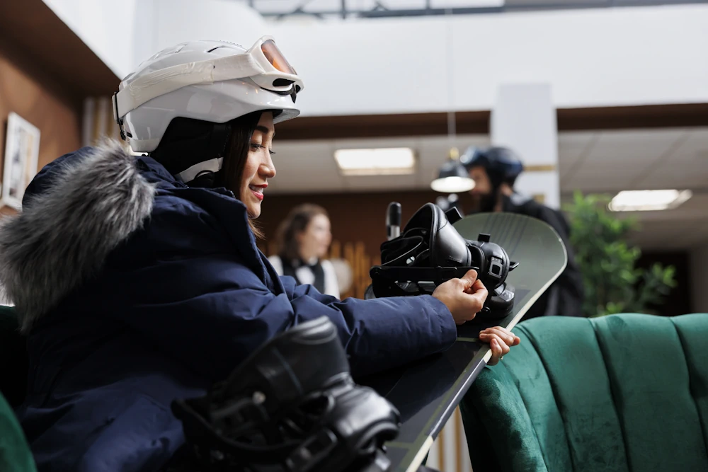 Asian snowboardgirl getting ready indoors